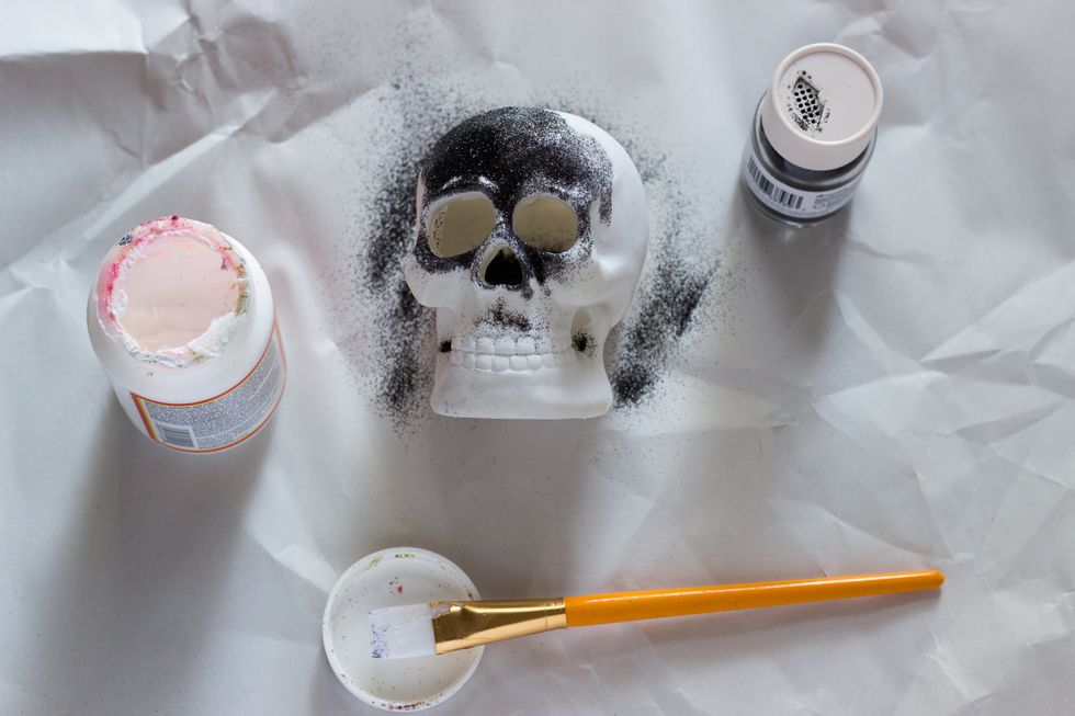 Once you apply Mod Podge to a section, sprinkle black glitter. Work your way around the skull with the Mod Podge and glitter under the whole skull is covered in black glitter.