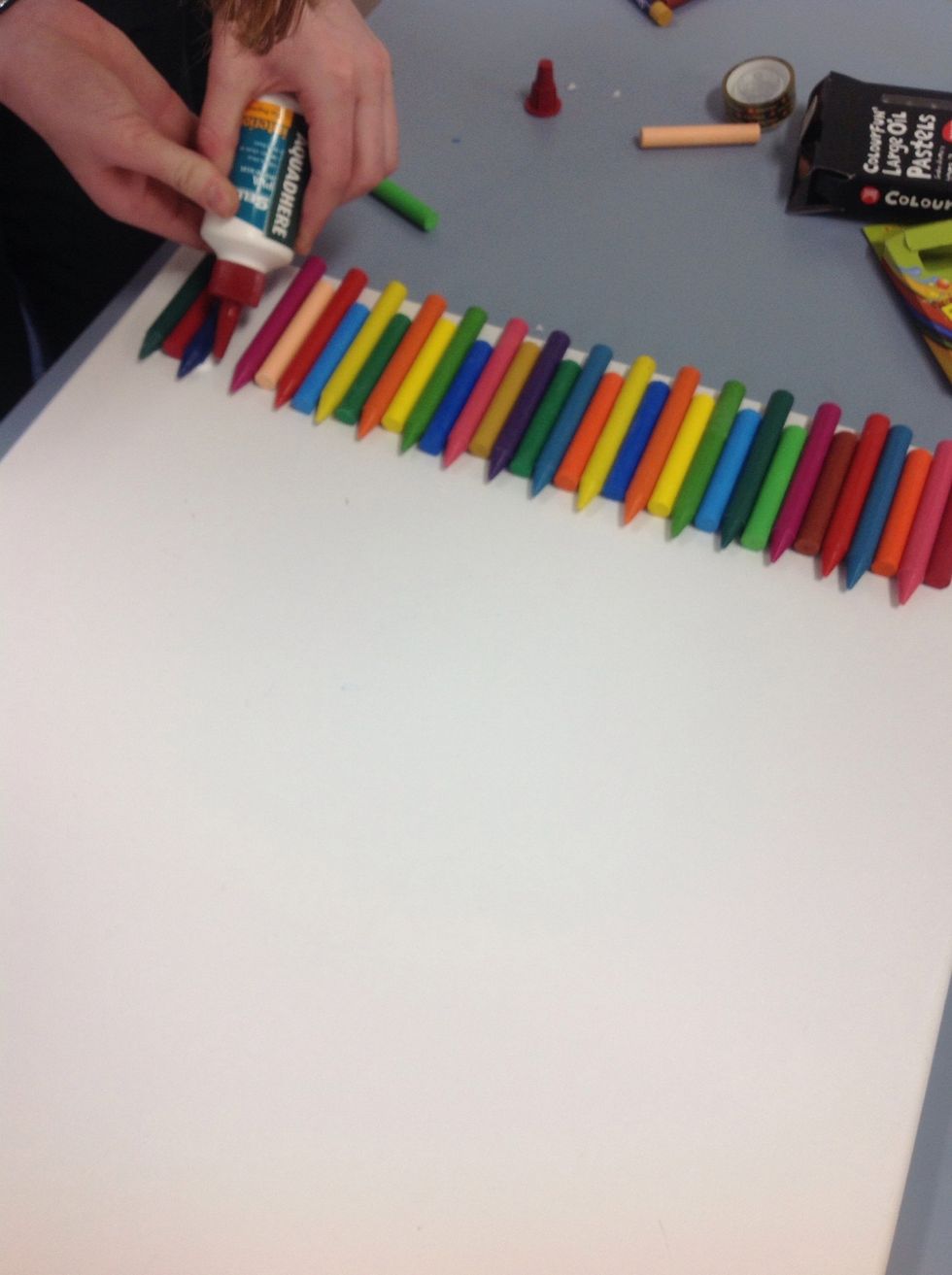 Once you are done start to glue the crayons to the canvas