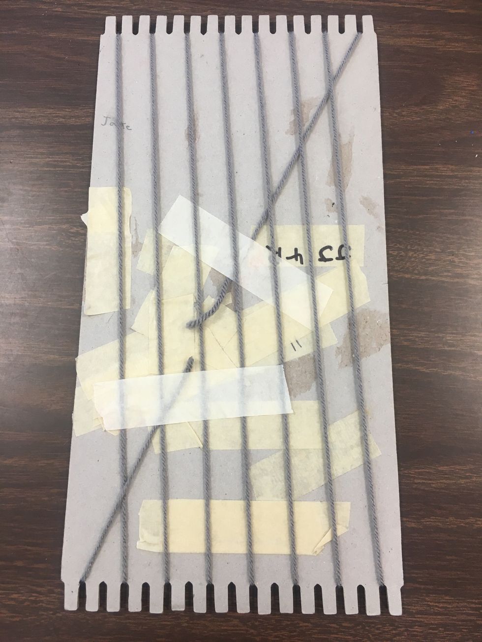 Once you finish w/ the first yarn secure the yarn to the back of the cardboard the exact same way you secured the starting point, with a 4 in. piece of strong masking tape.