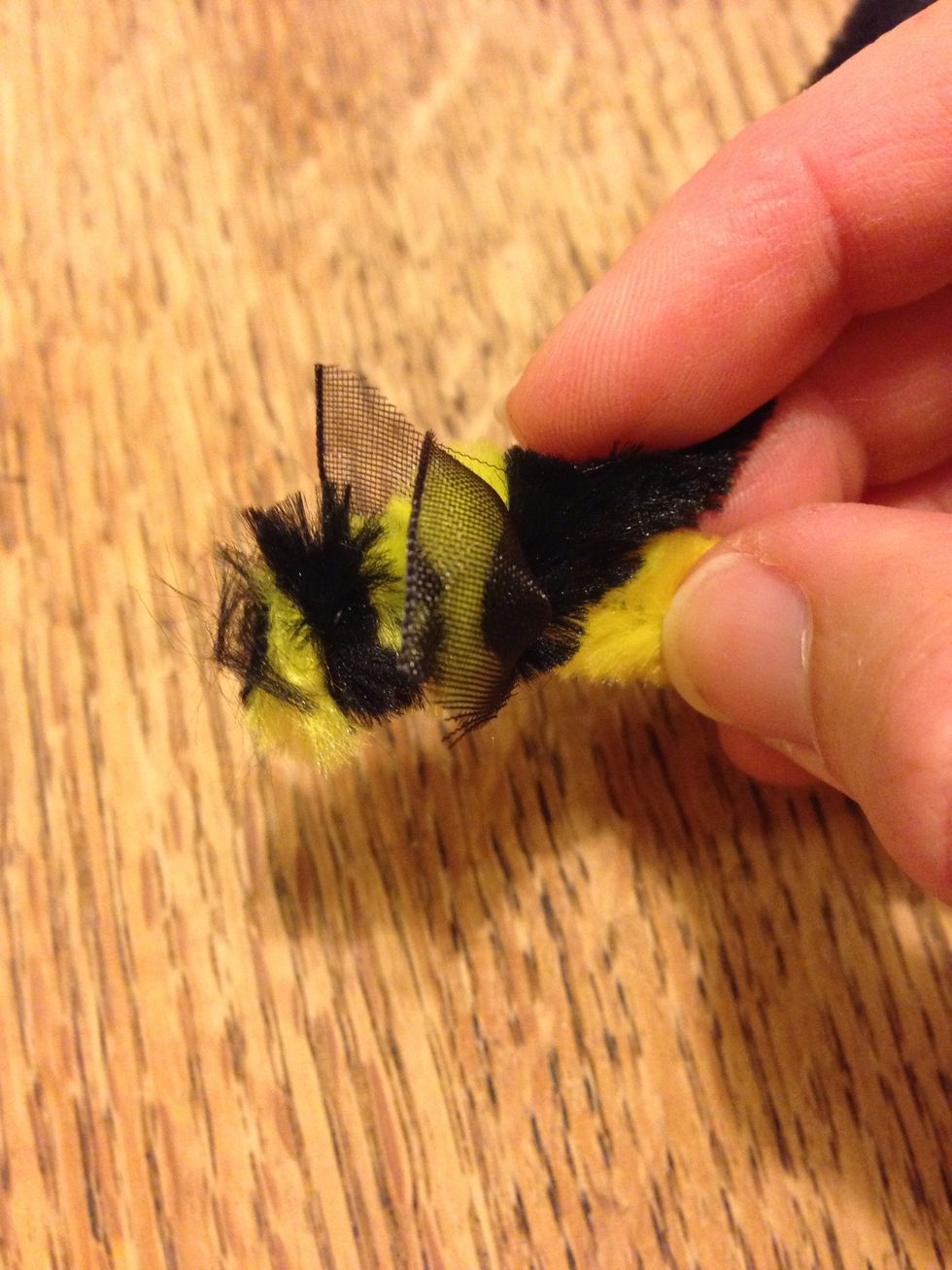 Once you have a couple of turns, place a small piece of ribbon in between to make the wings and keep twisting.