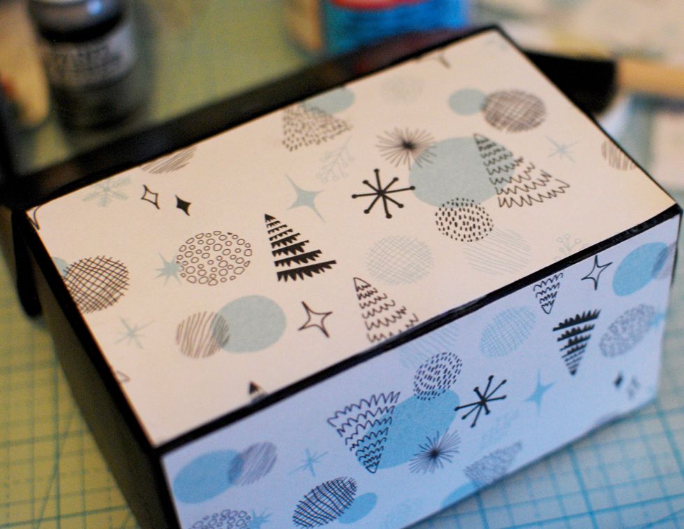 Once you have all the pieces cut, find some ModPodge and a sponge brush. Carefully sponge a thin layer onto the box and place the paper on top of it.