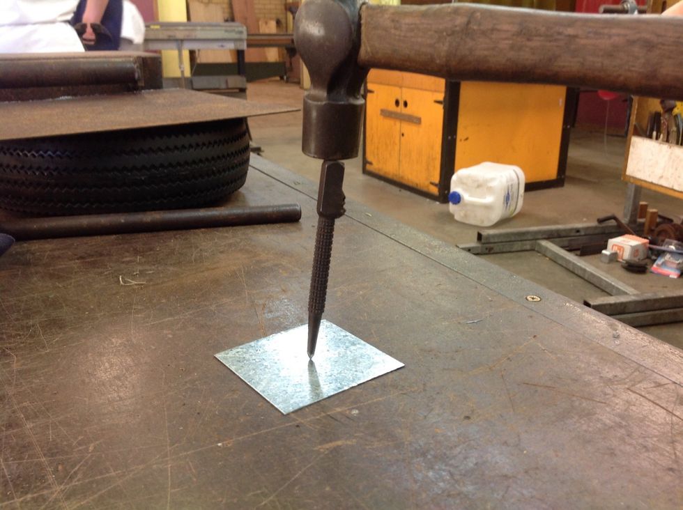Once you have found the centre point, use the Centre Punch and Ballpein Hammer to make a small indent in the Sheet Metal. This will direct the Drill Bit when drilling the hole.