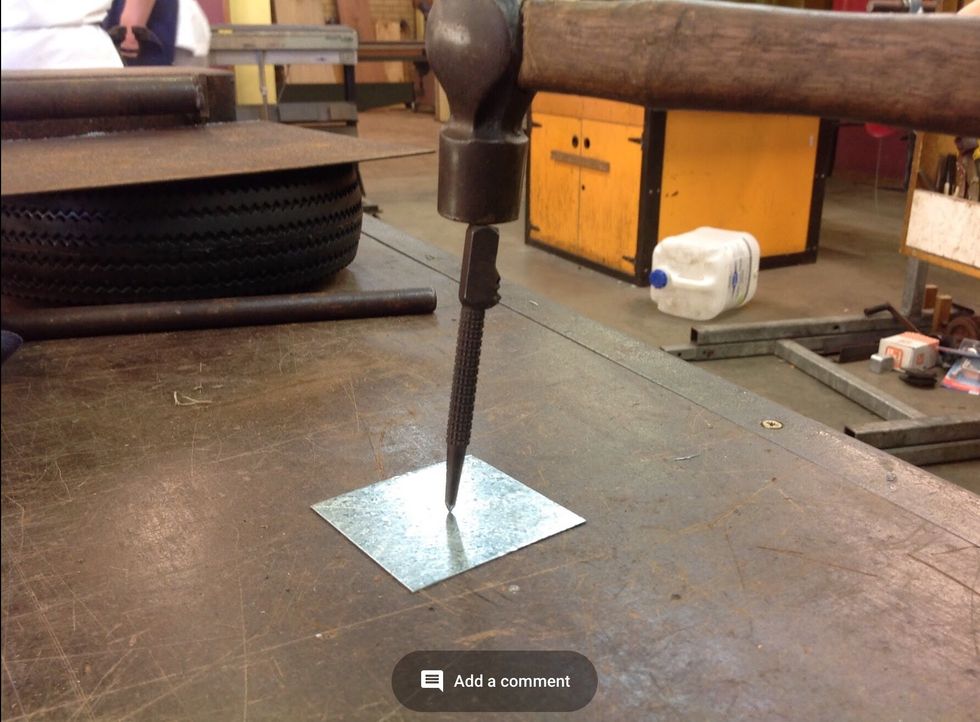 Once you have found the centre, use the centre punch to make an indent by hitting the centre punch which the ball pein hammer