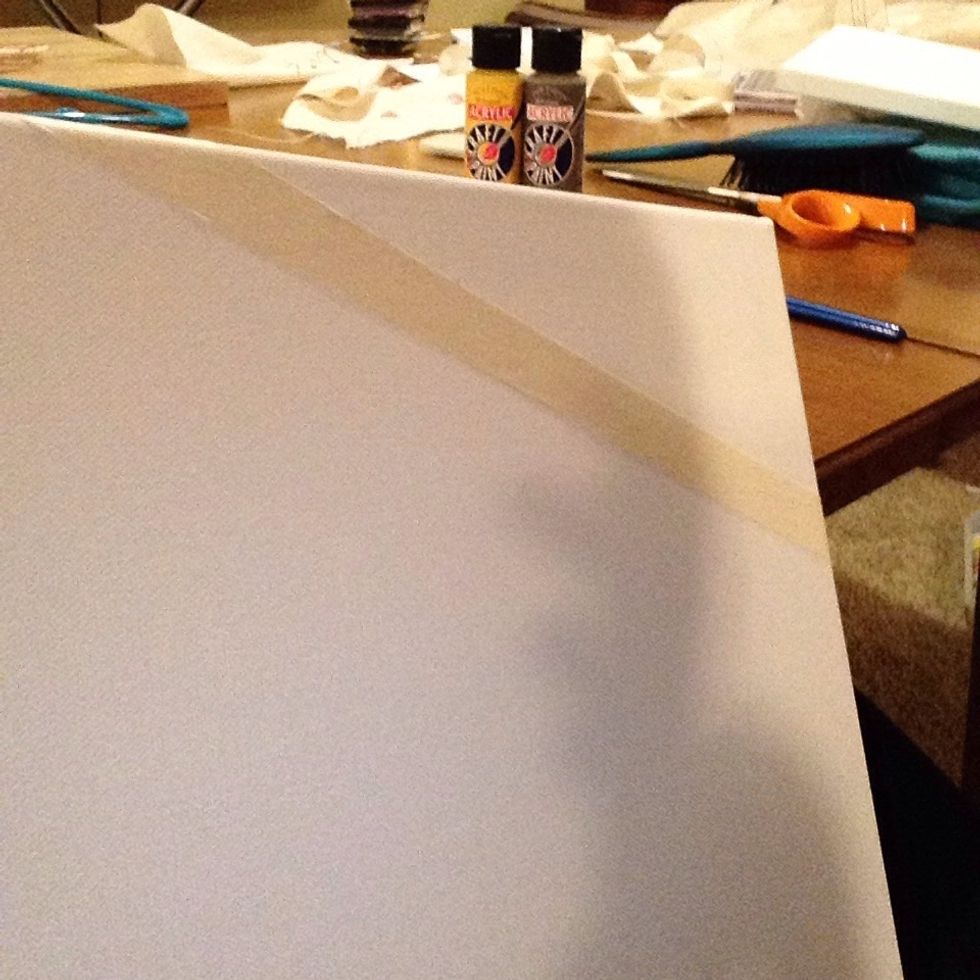 Once you have gathered all your supplies, place long strips of tape across the canvas randomly.