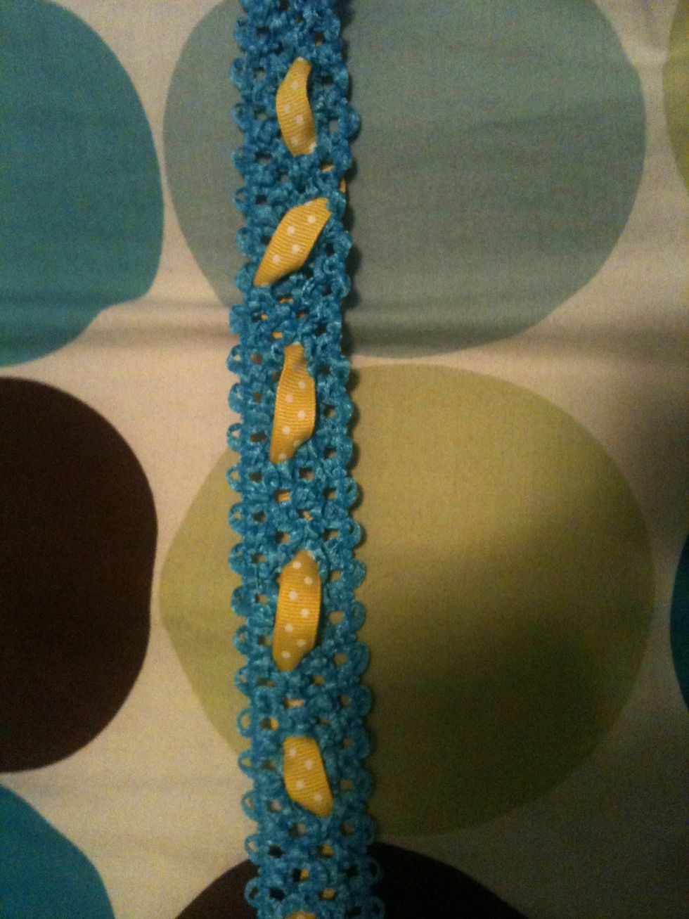 Once you have measured the size you are going to weeve the yellow ribbon through the blue material. Make sure your pattern is over and under in random places.
