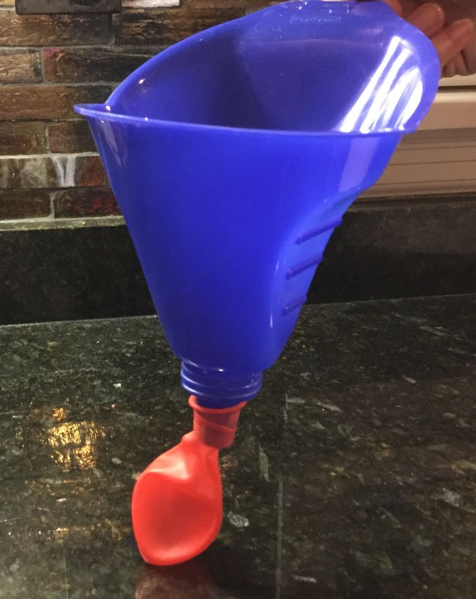 Once you have your materials take the funnel and put it inside the balloon.