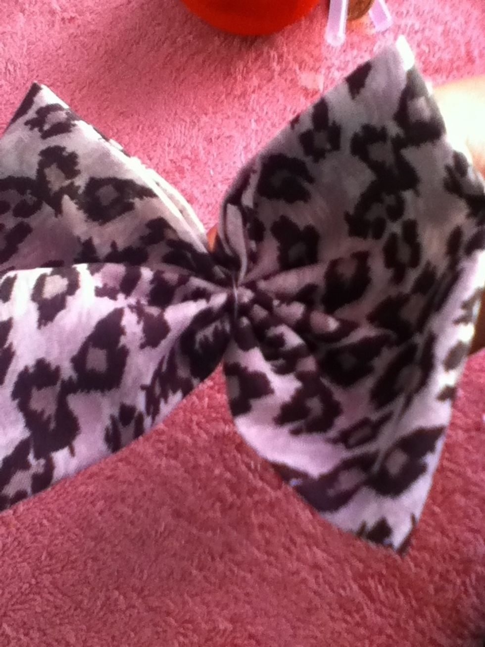 Once you're done pulling on the thread, wrap the thread around the middle of the bow. After you wrap it a couple of times make sure to put the needle through the wrapped thread to create a needle.