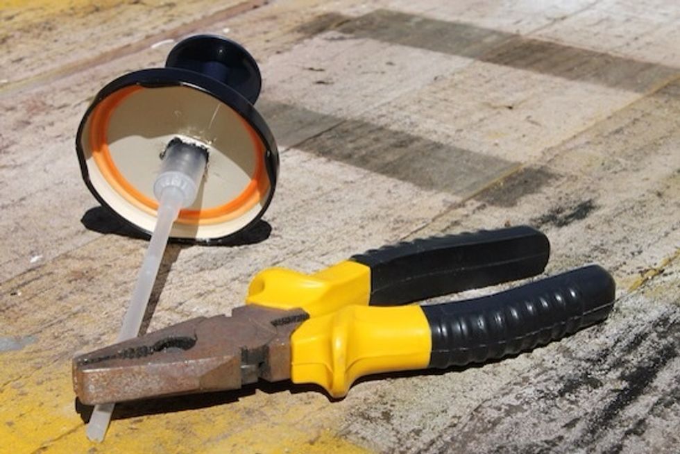 Once you\u2019re drilled the lid you\u2019ll want to extend the hole so that your soap dispenser pump fits through. Use your metal pliers to stretch the size of the hole for this.