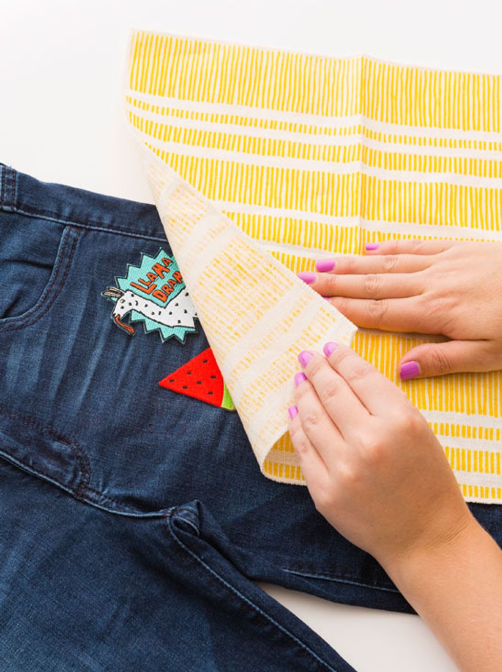 Once you\u2019re happy with your layout, carefully lay a clean dish towel over the top of your patches.