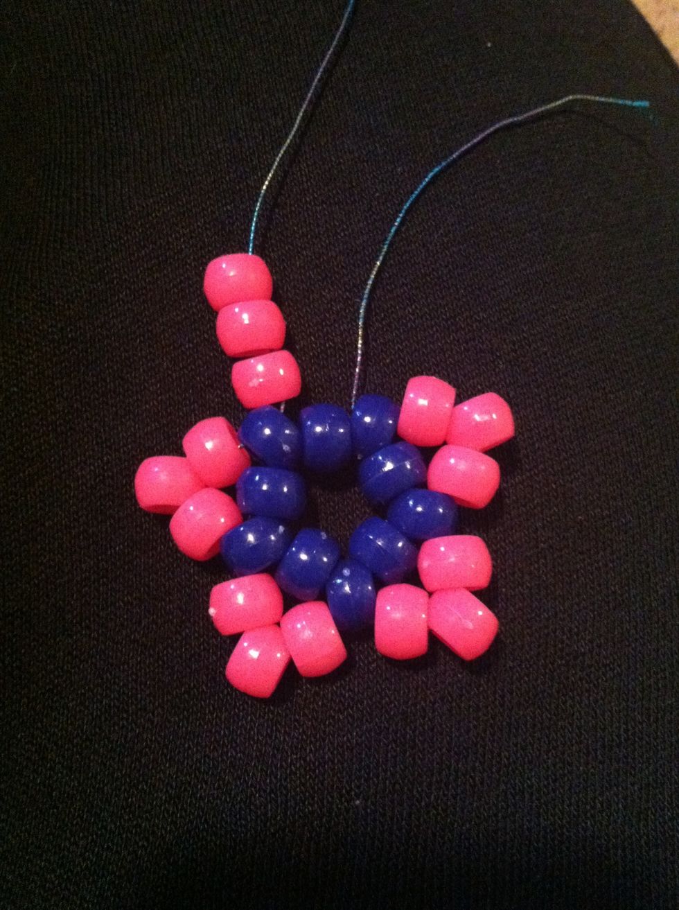 Once you've added all 15 beads use both strings sticking out to finish your star. Remember to pull the string right around your star so the points fall in place