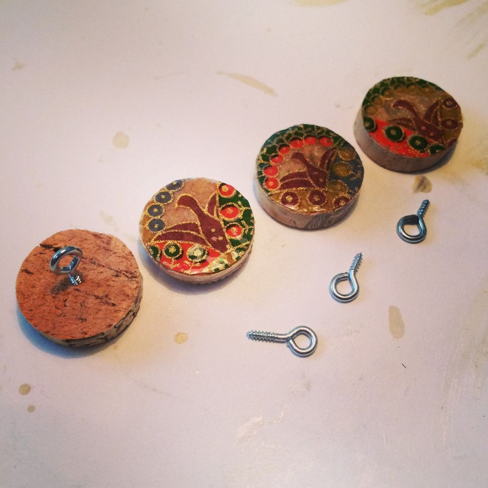 Once you've applied the wood varnish and it's dry, add the screw-in eyelets to the back of the cork round. I add it to the center