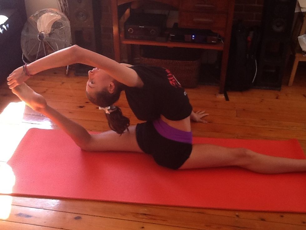 Once you've got your back leg bent up,you want to grab it with one hand. The reason you only grab with one hand is you need the other hand to balance your self.