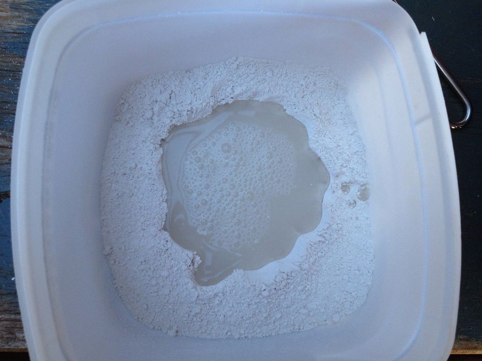 Once you've sifted roughly the amount of plaster you want, make a well in the middle of the powder, pour a bit of water in and start mixing with the plastic spoon.
