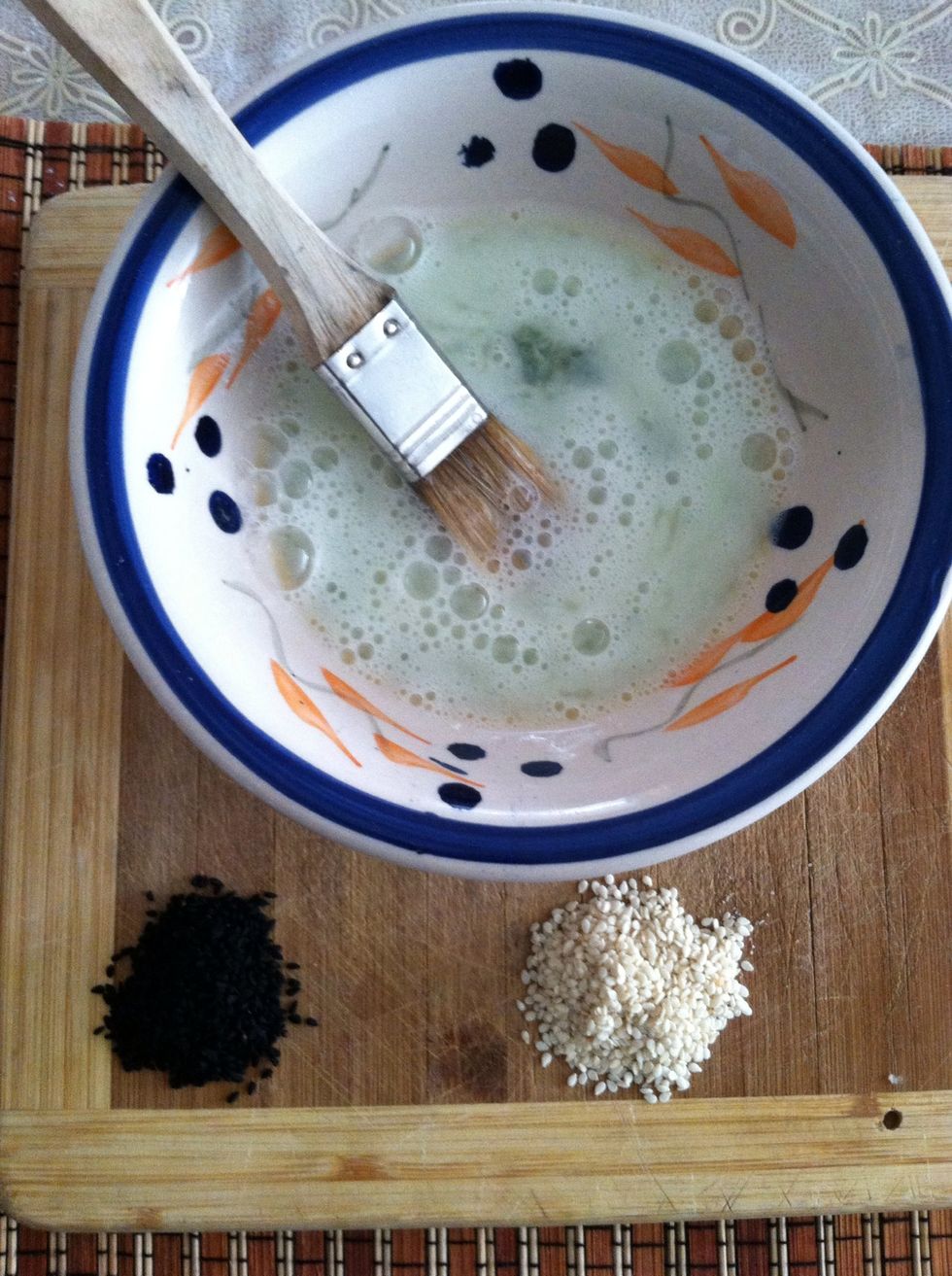 Once your bread is golden brown, take your egg wash that was set aside and brush on lightly. After covered in egg wash sprinkle your seeds and put back in the oven for 5 minutes