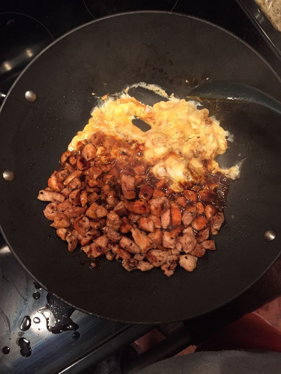 Once your chicken is cooked, add your beat eggs. Don't scramble them up, rather let it cook like an omelette. Once the bottom is cooked, flip it and mix it with the chicken.