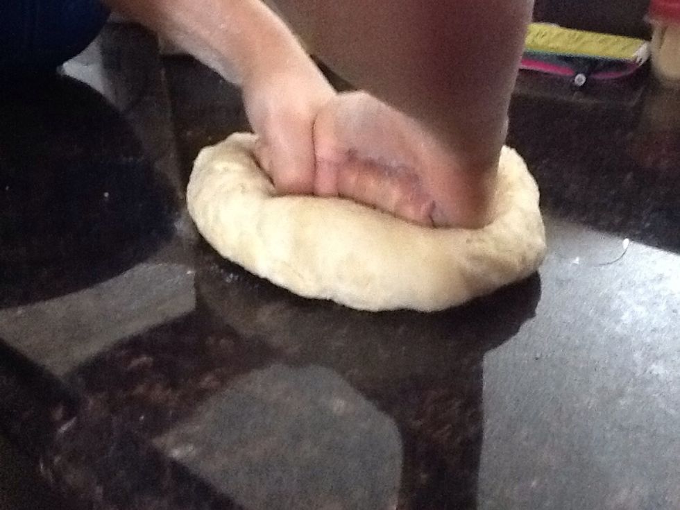 Once your done waiting for the dough to rise...Preheat the oven for 220' c or 425 ' f, take the dough out of the bowl and punch down on it. Knead the dough for 4-5 minutes.