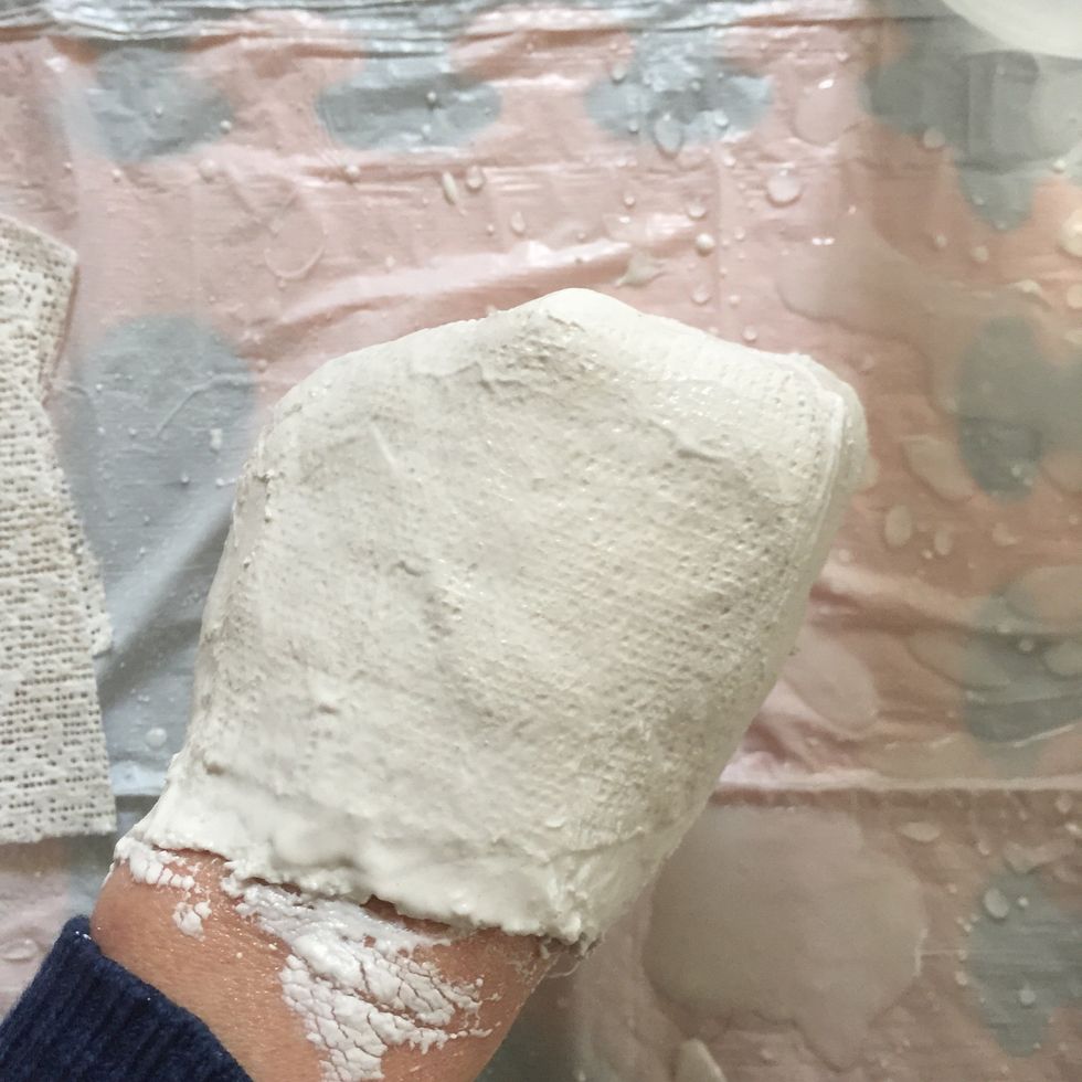 Once your hand is completely coated with 2-3 layers of plaster, hold it still and let it dry for 5-10 minutes
