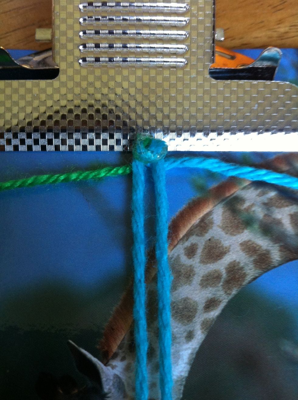 Once your knotted yarn has dried, trim off the extra on the top. After that, put it in between your base yarn.