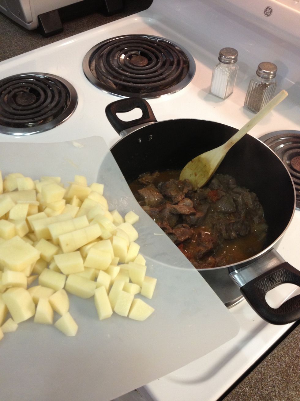 Once your meat is no longer red add your chopped potatoes.