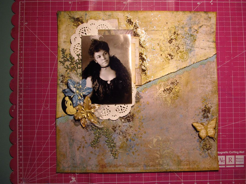 Once your photo is set, start adding your embellishment. Most everything is from the kit. Don't forget to tuck bits and pieces under your photo and in between your layers like with the doily.