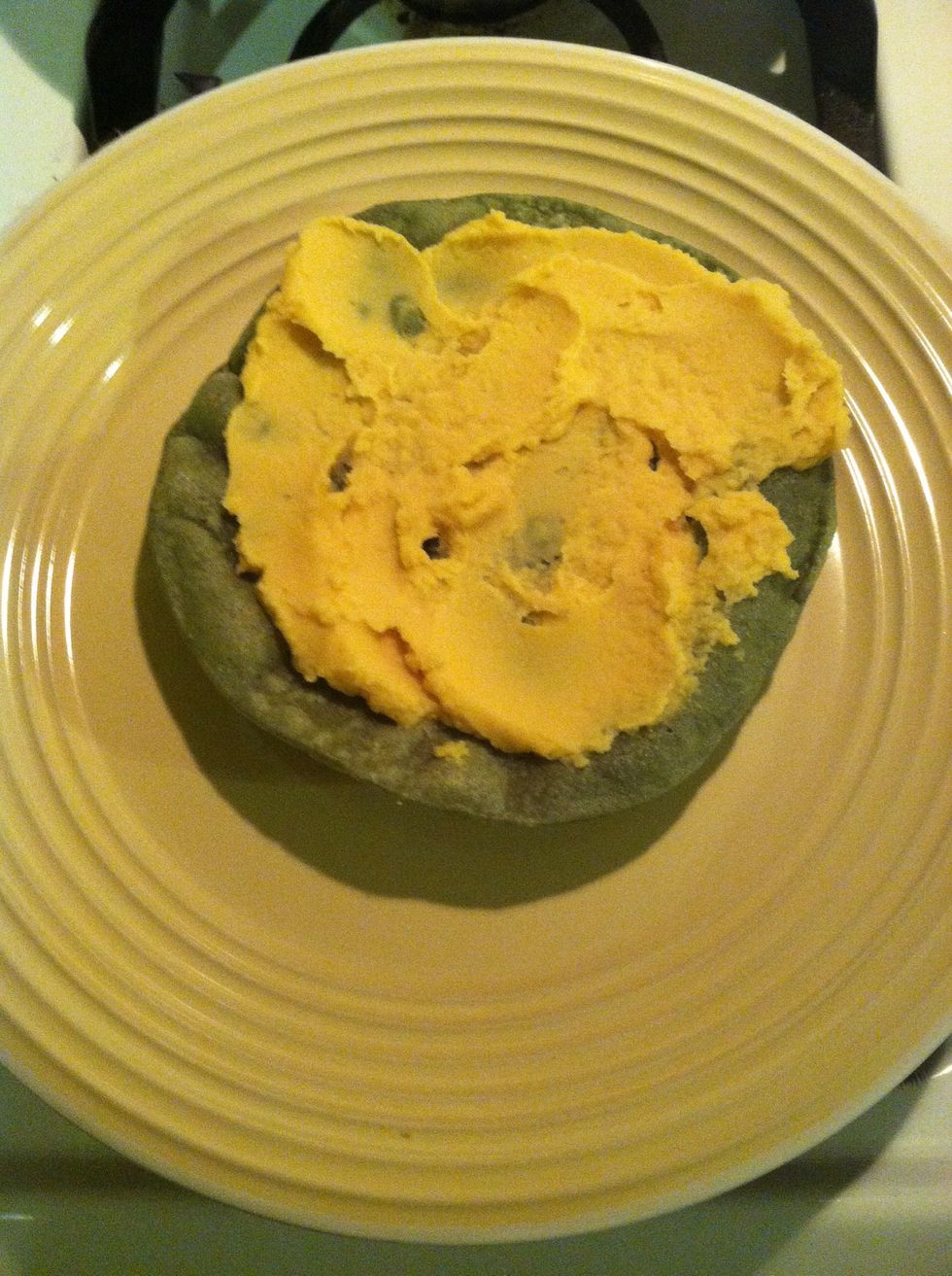 One fried blue corn tortilla shell a big tablespoons of the bean paste cover up the shell with the bean paste.