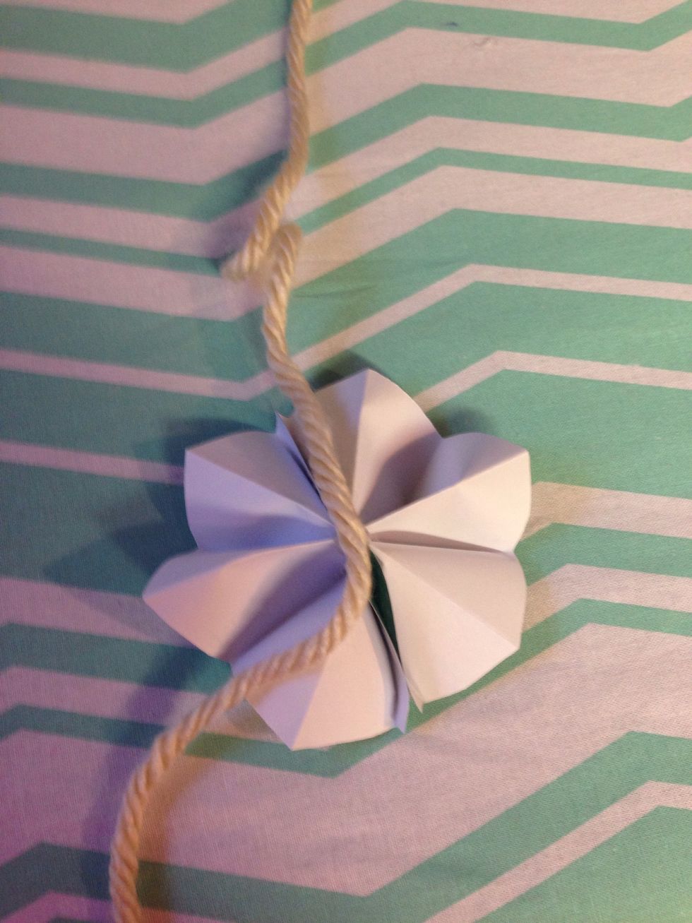 One idea is using the flowers to make a garland. Just glue the backs of the flowers to the yarn or ribbon.