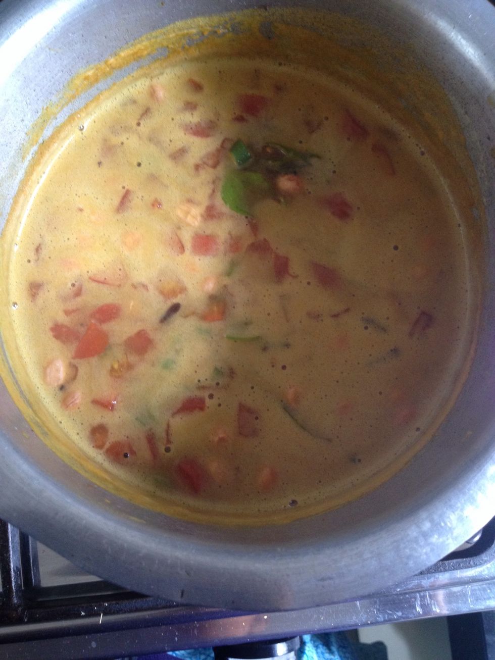 One it starts to boil add in green chilies and tomato. Let all cook for abt 10 mins