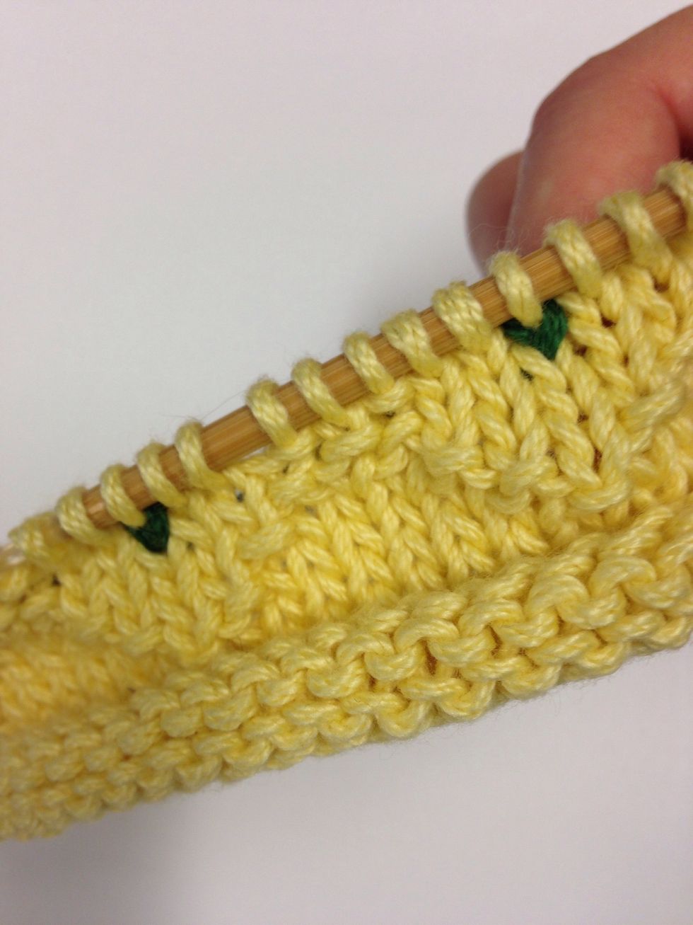 One this row, you will complete the "v" with a pearl stitch every 8th stitch, at the same time you add a green stitch in the center of each "v."