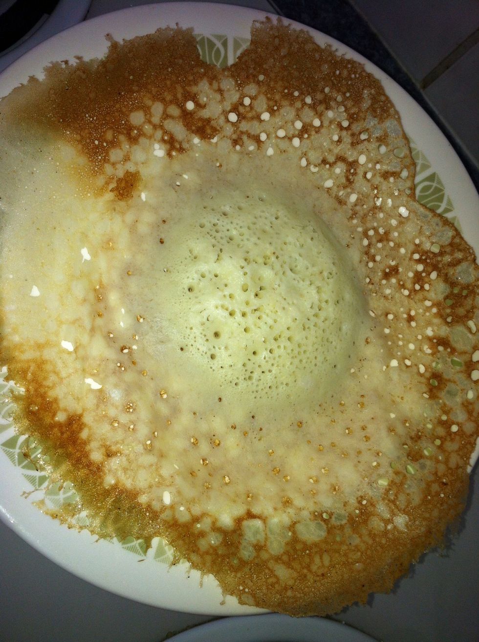 Only cook this one side. Do not flip it. A good appam should have many holes in the centre when cooking.This makes a fluffy pancake.