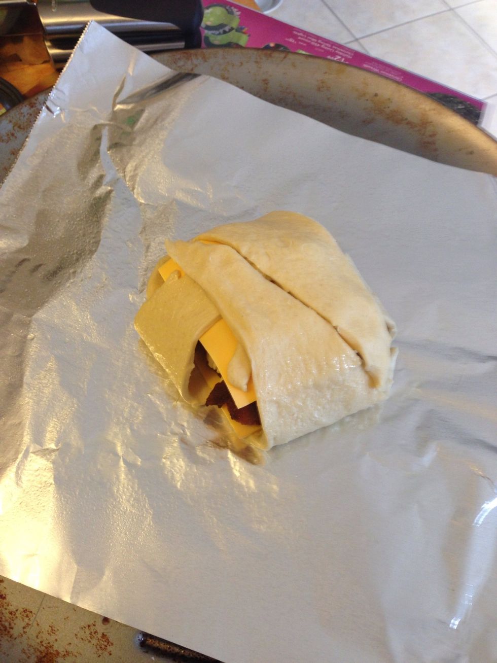 Oops. I added more bacon and then topped with cheese before folding over. 1st try turned out good but the 2nd one ( the rest of the crescent rolls) I closed up the sides a lil more. But not necessary.