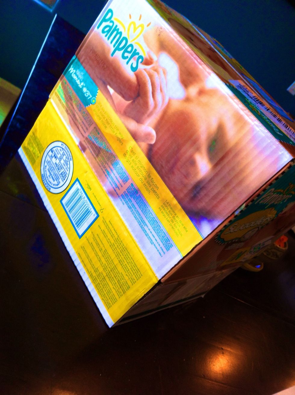 Open bottom of diaper box. Tape flaps on corners to hold it open (shown here). Open end will be the bottom of puppet theatre.