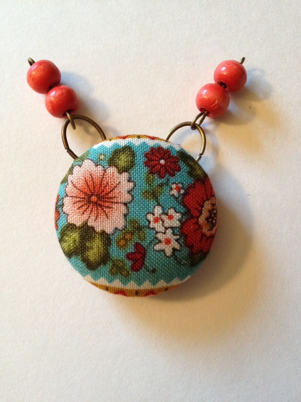 Open one loop of eye pin slightly to attach to one jump ring. Repeat on other side of button.