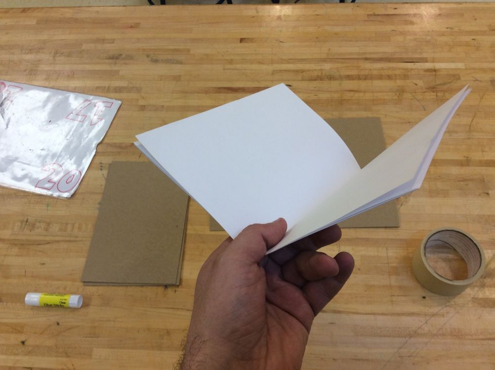 Open one piece of folded paper and put the other folded papers inside, making a paper booklet. (be sure the papers are stacked on top of one another, with the folds lined up)