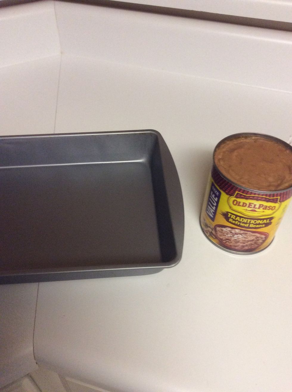 Open refried beans and spread into pan