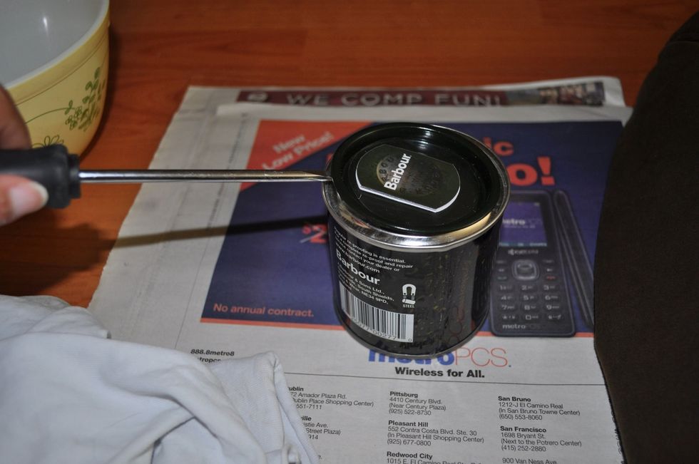 Open the can of wax. A screwdriver works well.