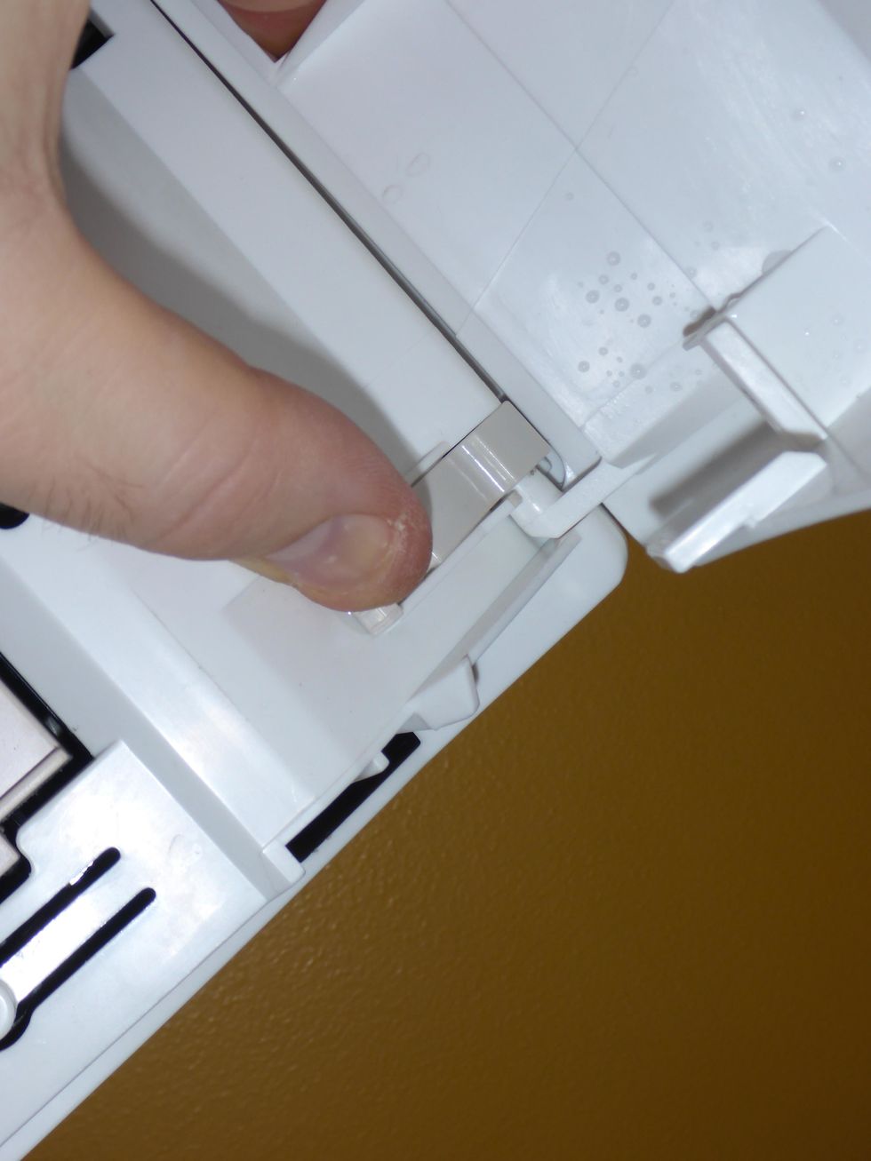 Open the front cover and remove it. It's usually secured in place by two plastic tabs, one on each side. Once the front cover is removed, it can be cleaned.