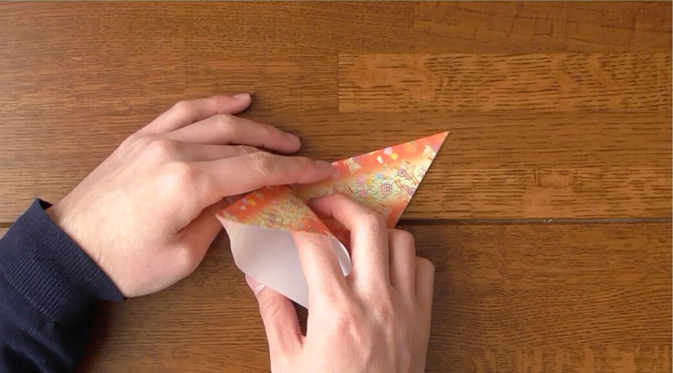 Open top layer and squash fold left corner to the bottom corner.  Fold right flap all the way to the left.  Open top layer and squash fold left corner to the bottom corner.