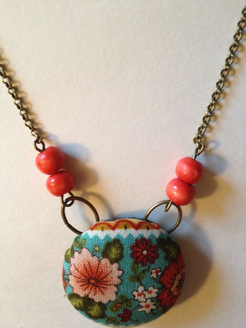 Open top loop of eye pin and attach to one length of chain. Repeat on other side of button.