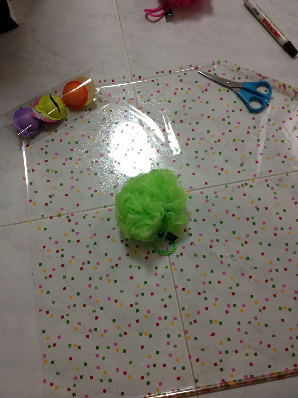 Open up the plastic wrapping and estimate the size to wrap 1loofah & 2shower gel. Here i use my marble flooring as guide line.