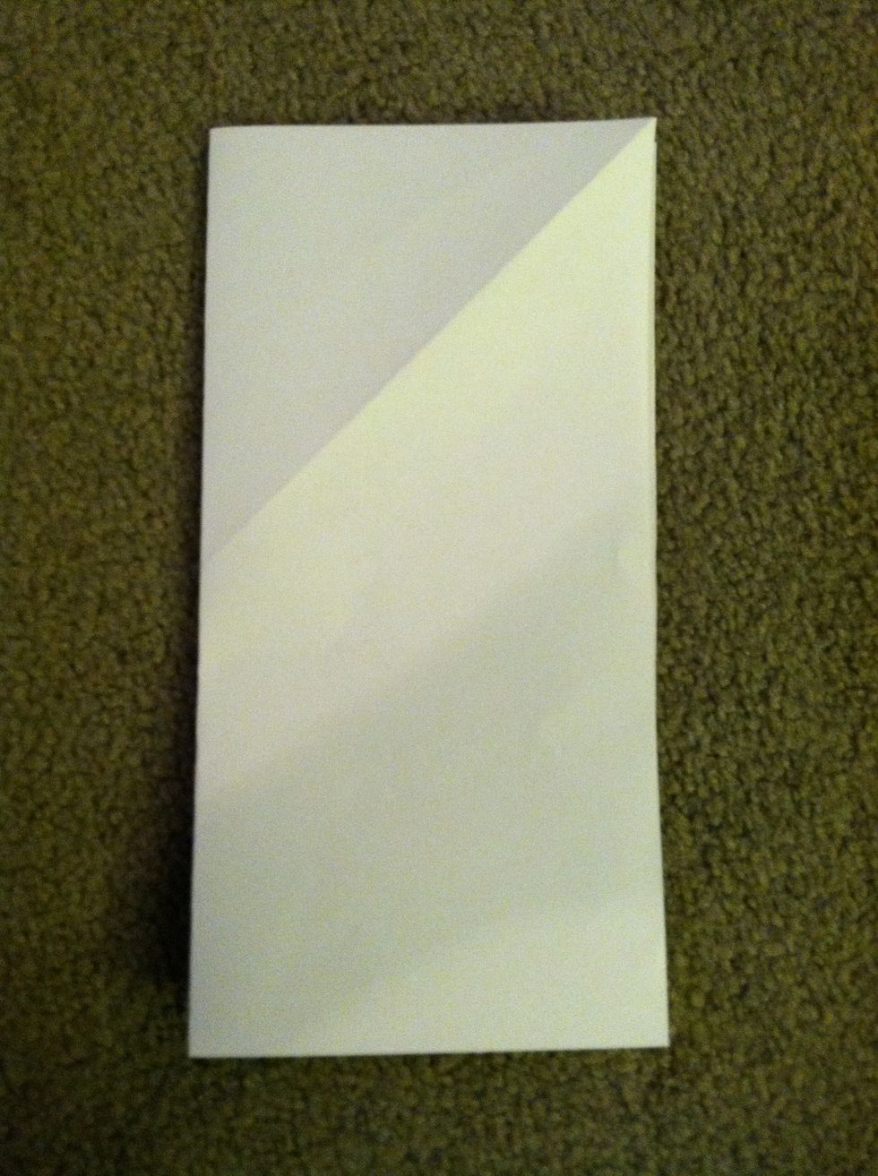 Open up the triangle and you will have a square. Fold that in half vertically or horizontally so it forms a rectangle.