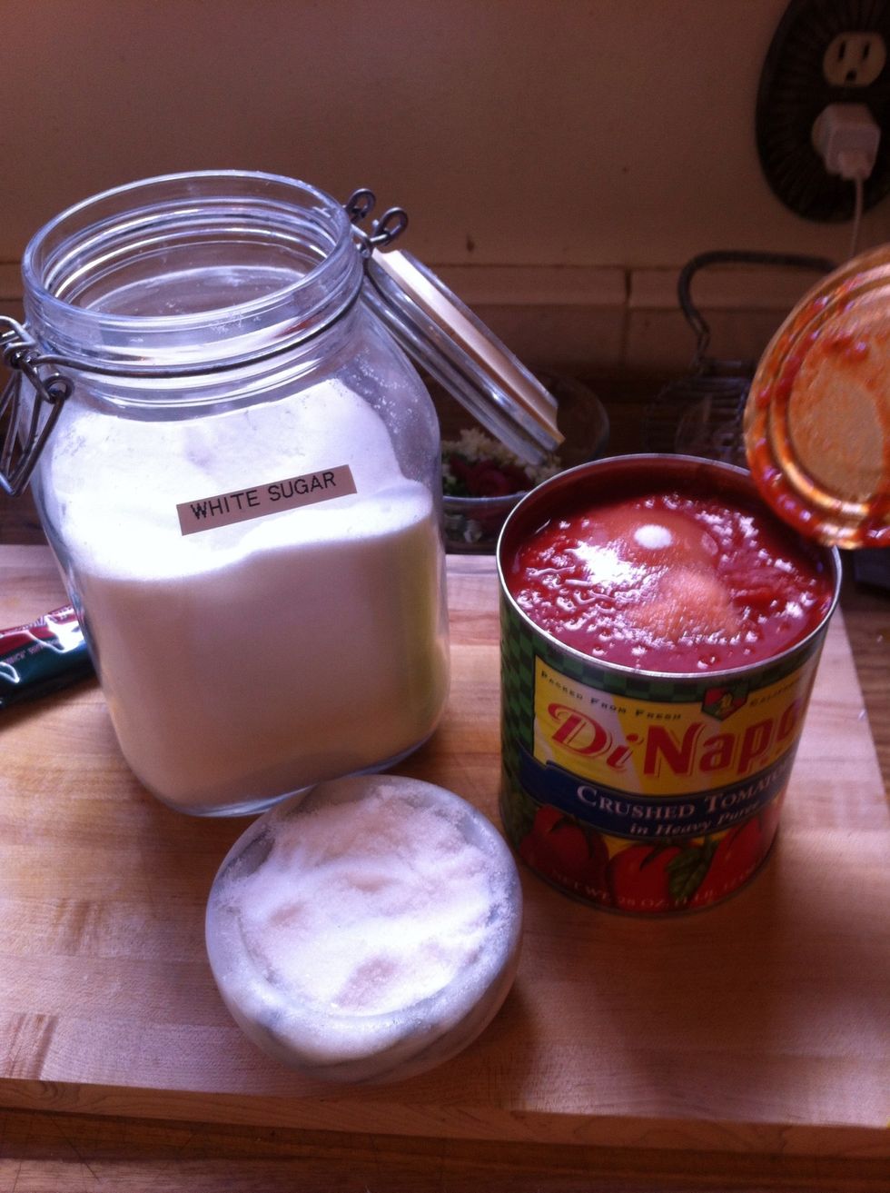 open your can of crushed tomatoes and add your salt and sugar into the can (trust me it will be easier when you are throwing it all together later)