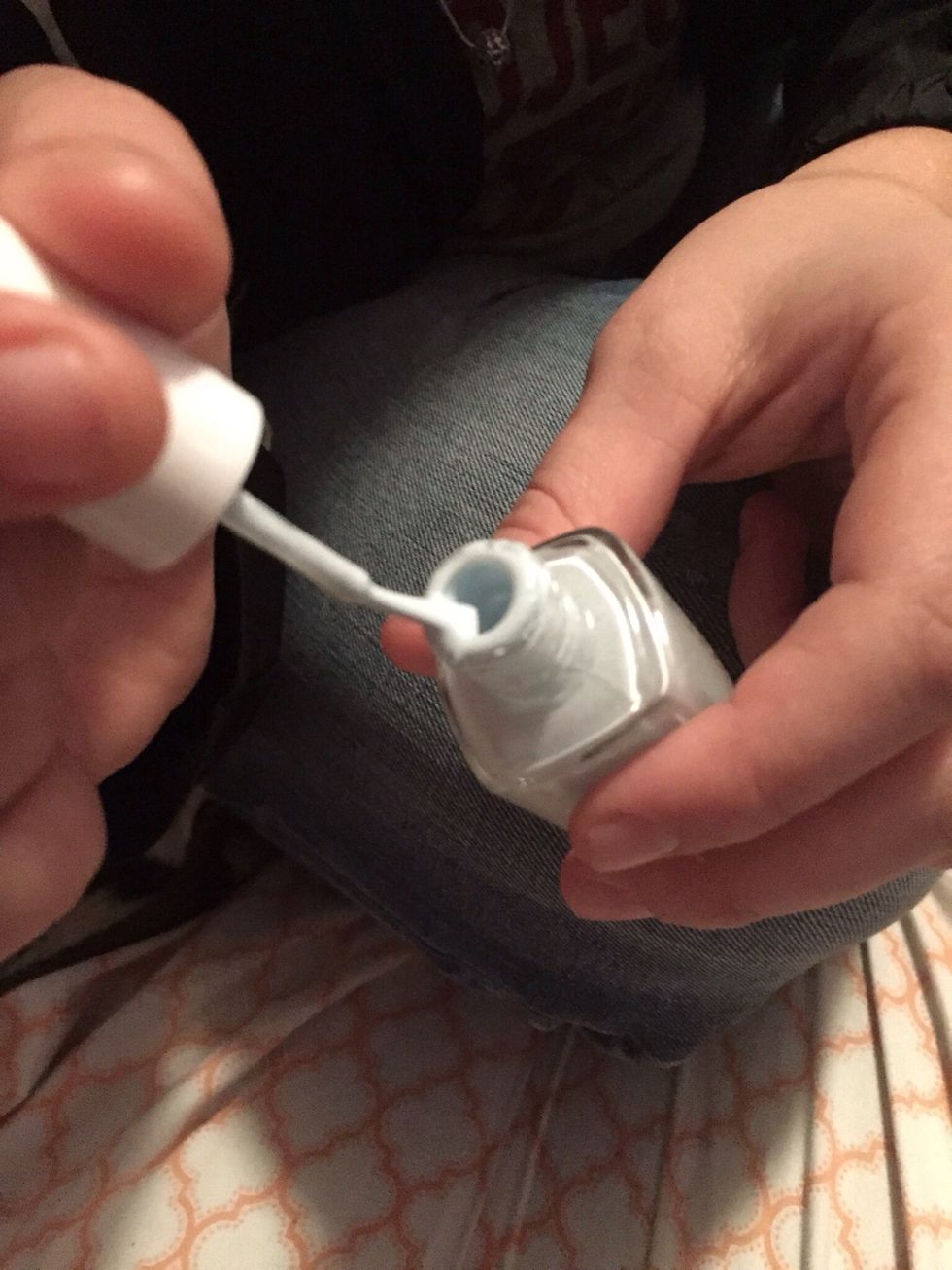 Open your desired nail polish color, dip the brush in a few times and rub one or both sides of the brush across the very top of the bottle. This is so there's not a huge glob of nail polish dripping