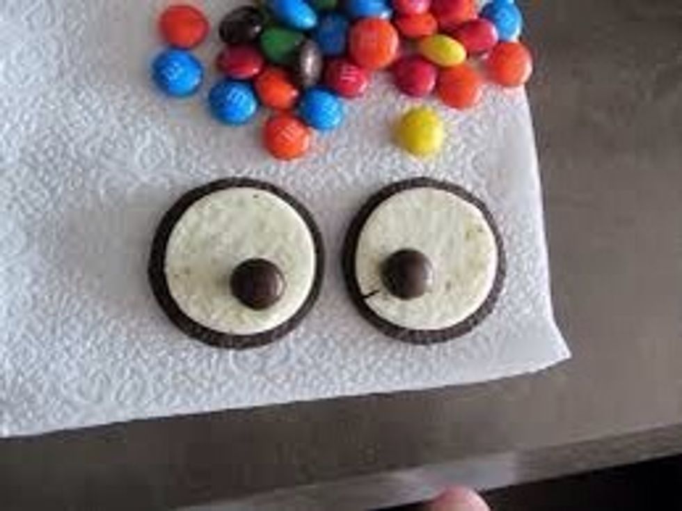 Open your M&M pack and choose 2 brown M&M for the owls eyes. Press down slowly so the cookies won't fall apart.