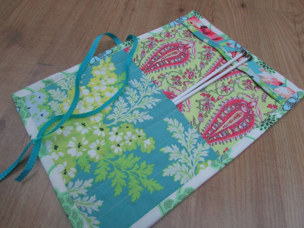 Opened up, it reveals a large pocket that hold up to ten single or paired needles, depending on their sizes, and a top tiny pocket to tuck the needle top down so they don't fall out.