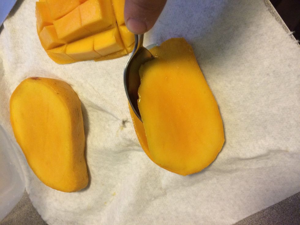 Option 2: use a spoon to carve out flesh. It is the easiest way to get as close to the skin, keeping as much of the ripe, tasty mango as possible. Careful, it's slippery! Then freeze or dice. Enjoy!