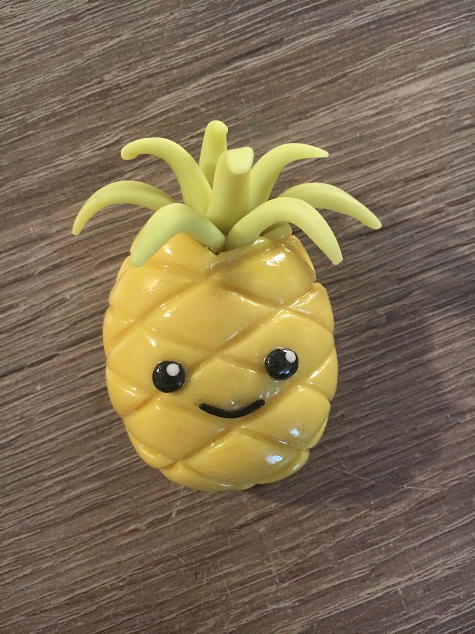 (Optional) If you want to add a face, take some black clay and roll it into small balls. Add them to the pineapple along with a small log for the mouth.
