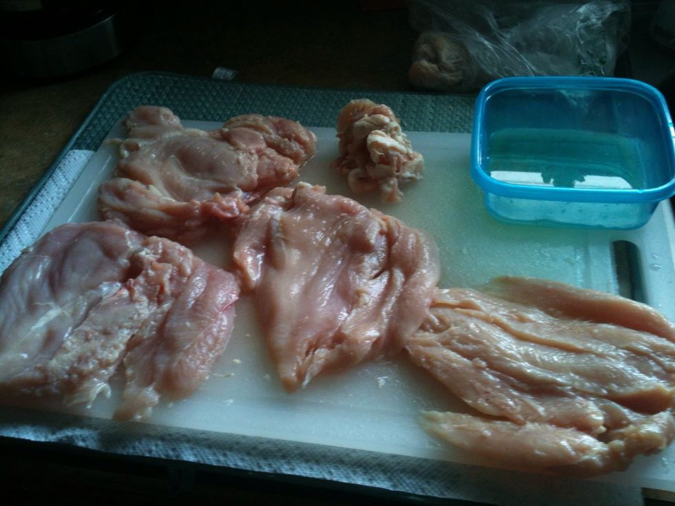 Our four chicken breasts (the supplies calls for two, but we are making dinner for the family). After you remove the fat (see pile next to tupper), lay your chicken breast like so.