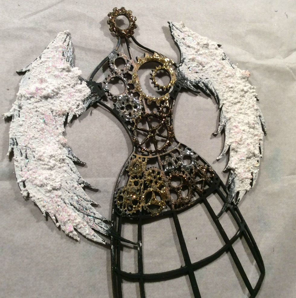 Our steampunk lady was painted black first, then SnowTex was added to the wings, then topped it with Crystal Stickles. The bodice of gears were stickled with gold, silver & copper.