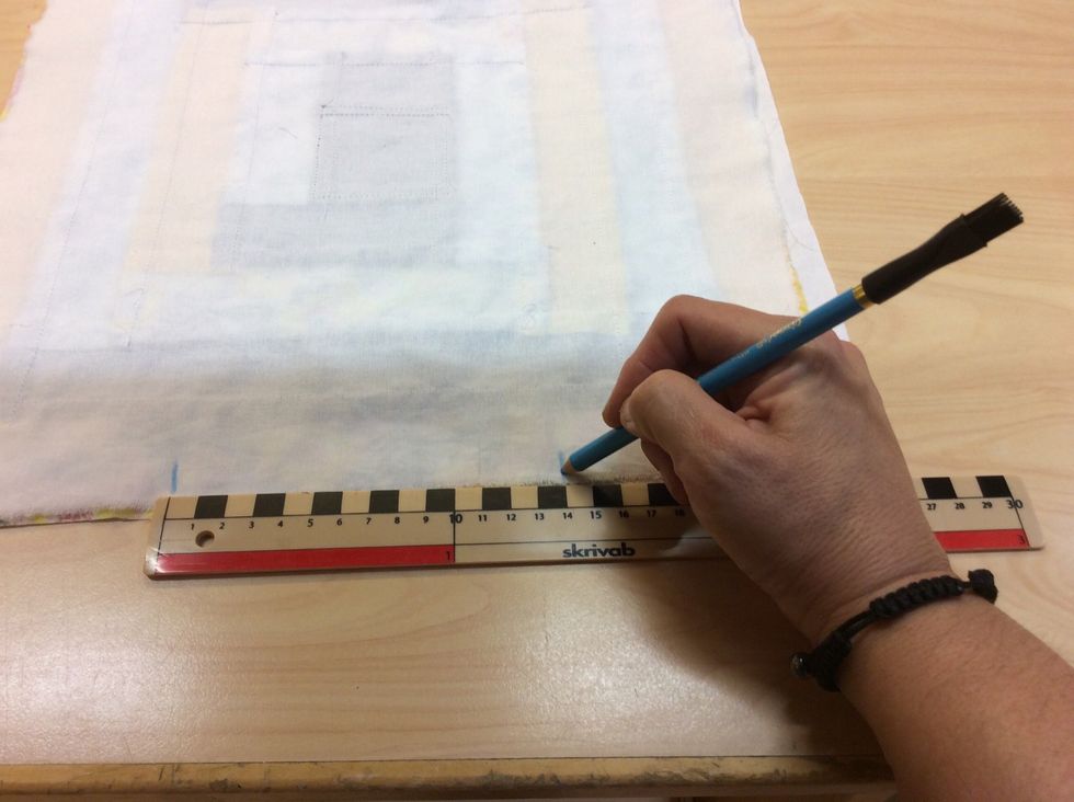 P\u00e5 en av sidorna markerar du ut med en tygpenna 2 sm\u00e5 streck med ca 14 cm mellanrum.
