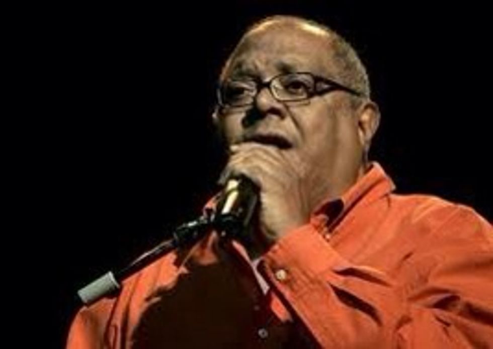 Pablo Milan\u00e9s va n\u00e8ixer l'any 1943. \u00c9s un compositor, cantant, guitarrista i cantautor cub\u00e0 de jazz. En aquesta fotografia surt Pablo Milan\u00e9s a un concert a Madrid.